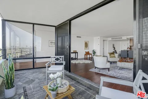 a living room with furniture a rug and a glass door