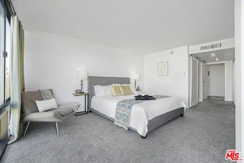 a bed room with a bed and a chair