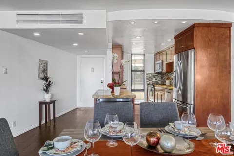 a kitchen with stainless steel appliances granite countertop a dining table and chairs