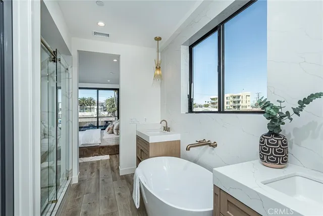 a bathroom with a granite countertop sink a toilet a mirror and shower