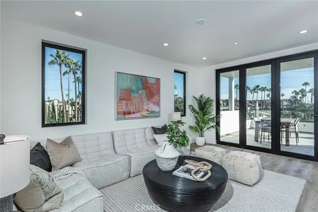 a living room with furniture potted plant and a large window
