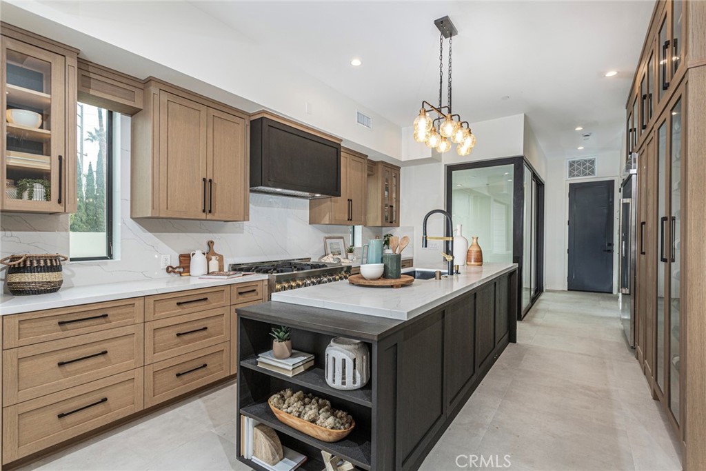 328 3rd Street Huntington Beach, CA 92648 - Photo 10 of 42 a kitchen with kitchen island granite countertop a sink stove and cabinets