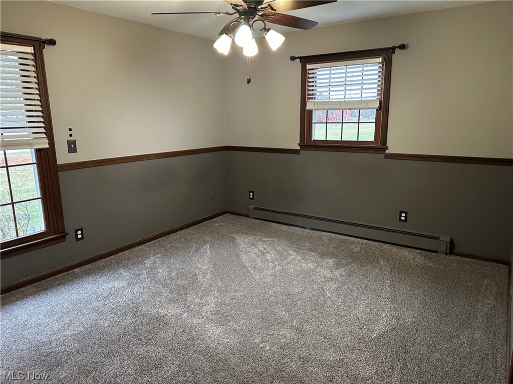 13055 Unity Road New Springfield, OH 44443 - Photo 28 of 49 Unfurnished room with baseboard heating, a wealth of natural light, carpet, and ceiling fan