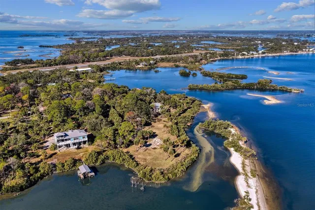 an aerial view of ocean and residential houses with outdoor space