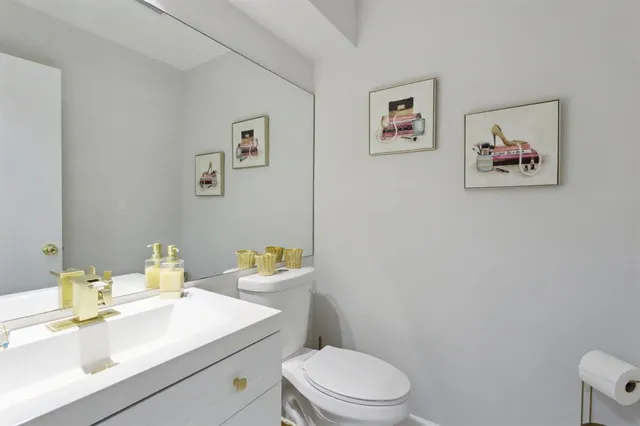 a bathroom with a sink mirror vanity and toilet
