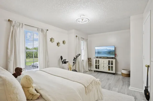 a bedroom with a bed and a flat tv screen on dresser