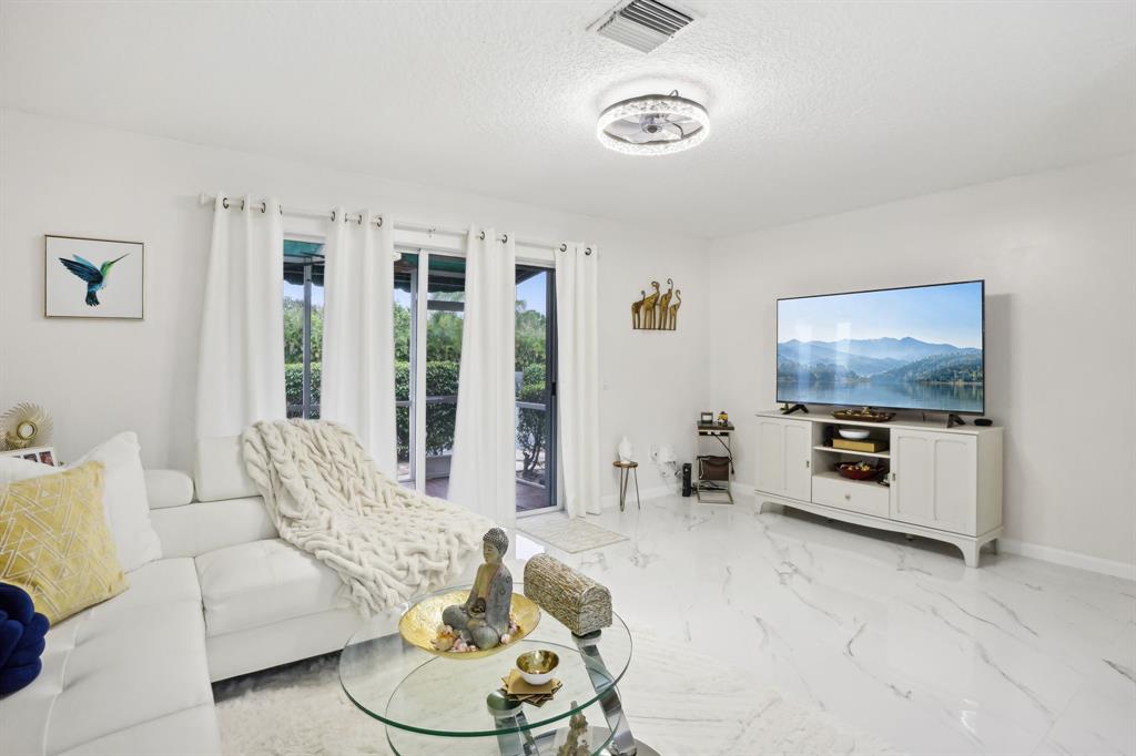 368 Waterside Drive Hypoluxo, FL 33462 - Photo 21 of 24 a living room with furniture and a flat screen tv
