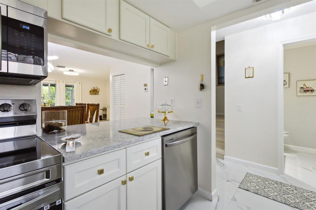 368 Waterside Drive Hypoluxo, FL 33462 - Photo 7 of 24 a kitchen with stainless steel appliances granite countertop a sink and cabinets