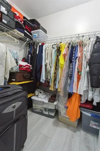 a view of walk in closet with clothes and shoes