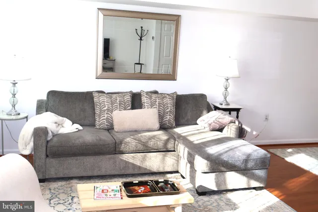 a living room with couches and a painting on the wall