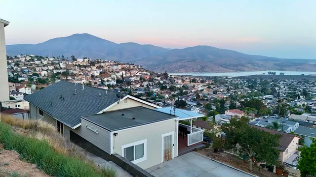 an aerial view of residential houses with outdoor space and trees