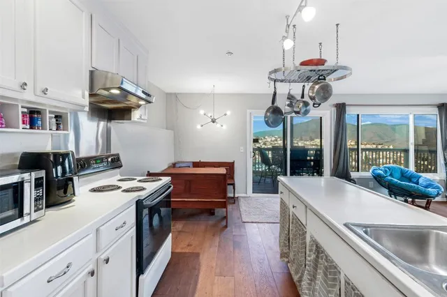 a kitchen with kitchen island granite countertop a sink a counter space appliances and cabinets