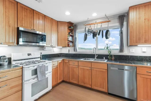 a kitchen with stainless steel appliances granite countertop a stove sink microwave and cabinets