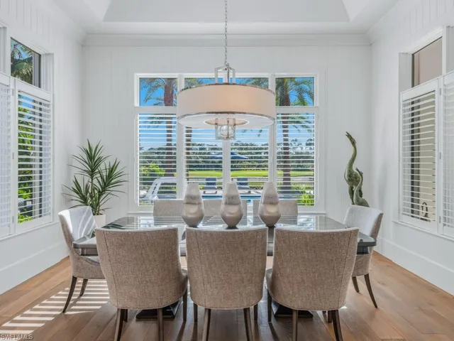 a kitchen with stainless steel appliances a dining table chairs and wooden floor
