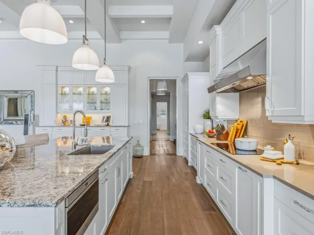 a large white kitchen with cabinets and wooden floor