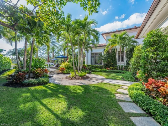 a front view of a house with a garden and lake view