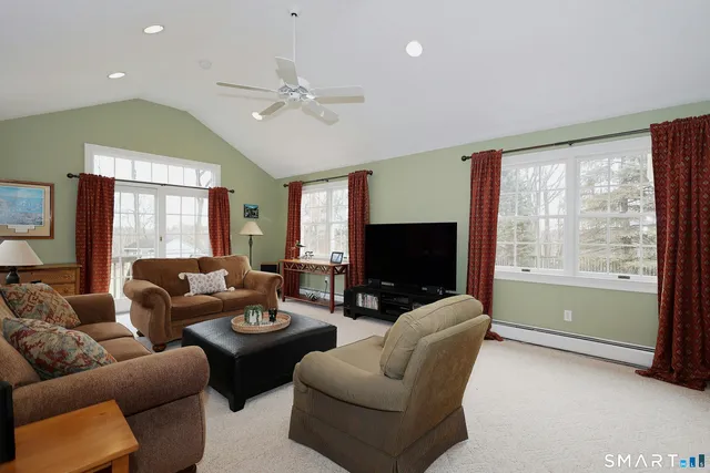 a living room with furniture a flat screen tv and a large window
