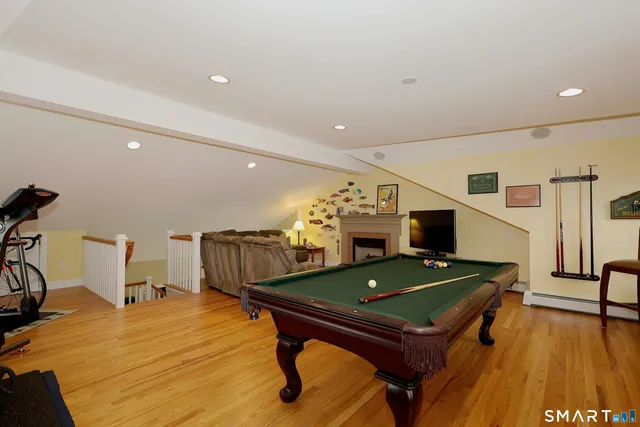 a living room with furniture pool table and a flat screen tv