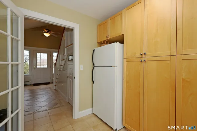 a view of a livingroom with wooden floor and a refrigerator