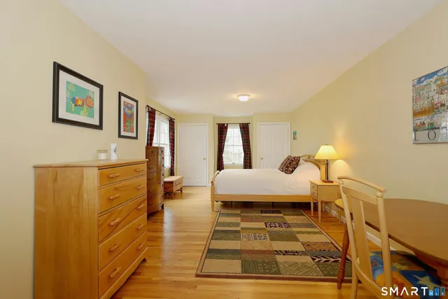 a spacious bedroom with a bed and a lamp on a table