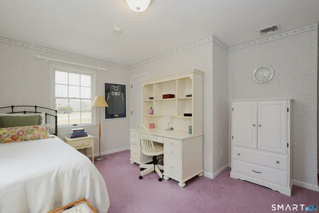 a bedroom with a bed and a flat tv screen on the dresser