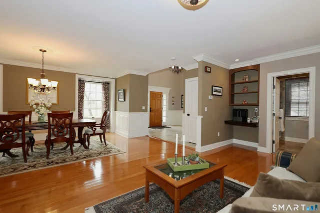 a living room with furniture dining table and a chandelier