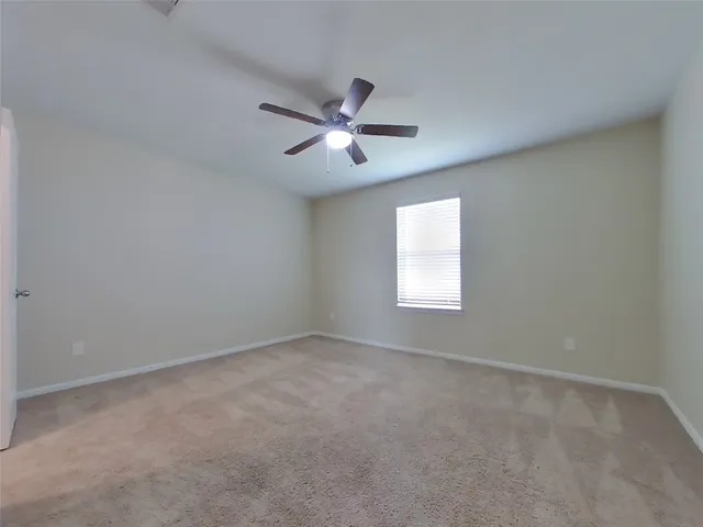 a view of empty room with ceiling fan