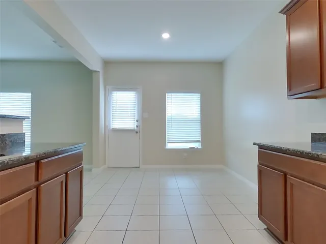 a kitchen with granite countertop a sink a stove and cabinets