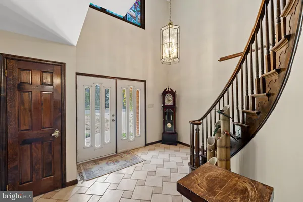 an empty room with wooden floor fireplace and windows
