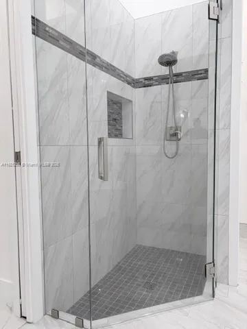 an empty room with chandelier fan and windows