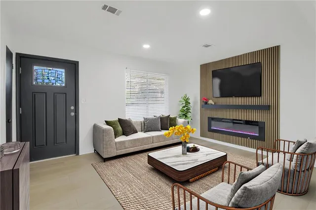 a living room with furniture a fireplace and a flat screen tv