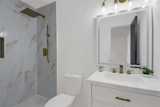 a bathroom with a sink a toilet and shower