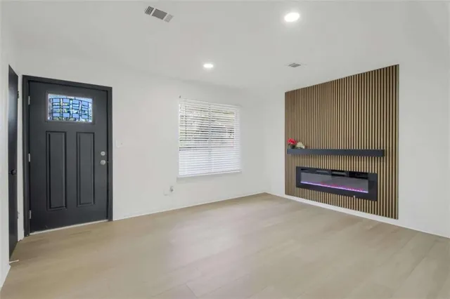 an empty room with windows and fireplace