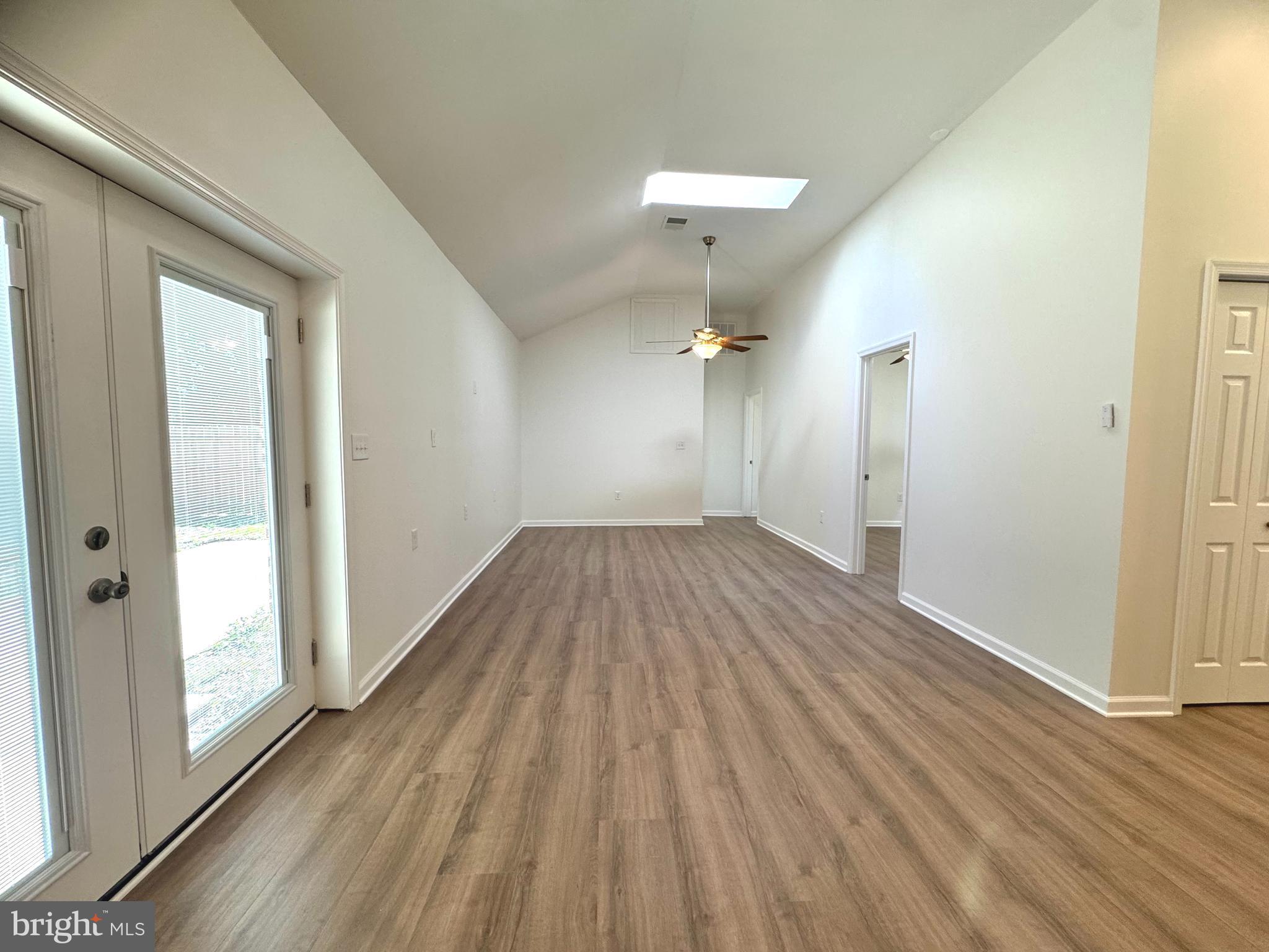 8190 Marshall Corner Road Pomfret, MD 20675 - Photo 11 of 28 a view of a room with wooden floor a ceiling fan