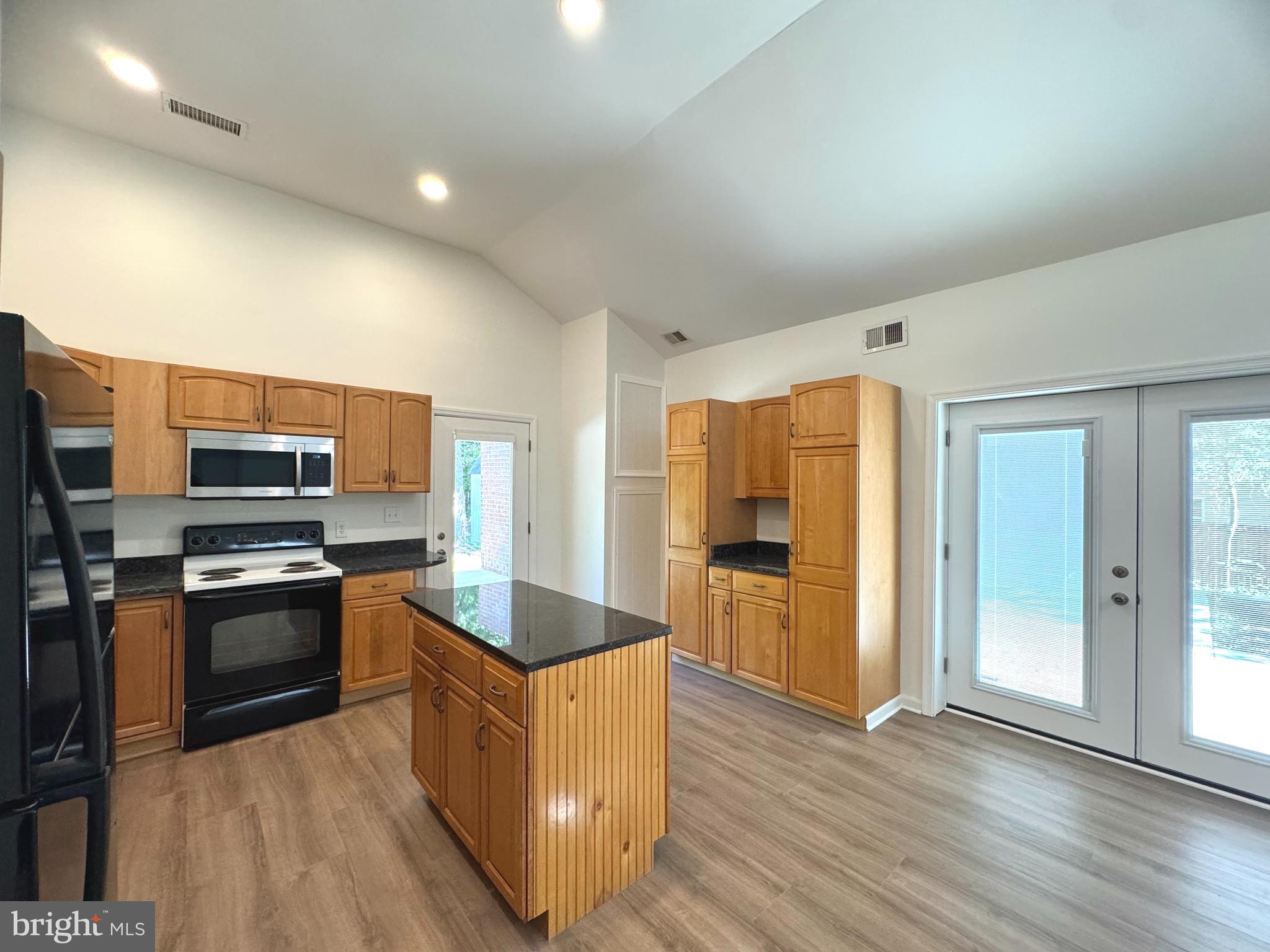 8190 Marshall Corner Road Pomfret, MD 20675 - Photo 8 of 28 a kitchen with stainless steel appliances granite countertop a stove top oven a sink dishwasher a refrigerator and a oven with wooden floor
