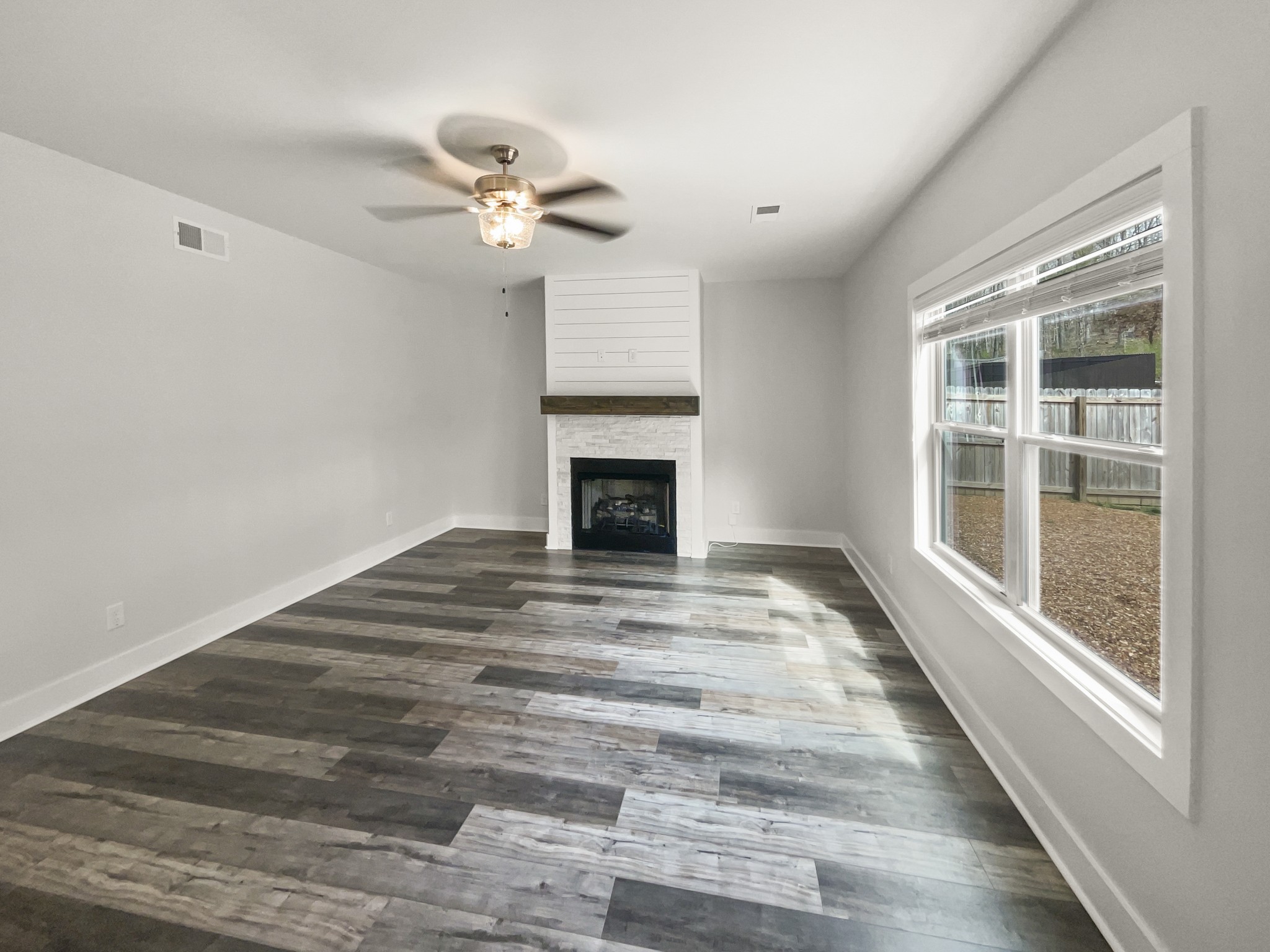 1672 Rains Road Clarksville, TN 37042 - Photo 3 of 23 a view of an empty room with wooden floor fireplace and a window
