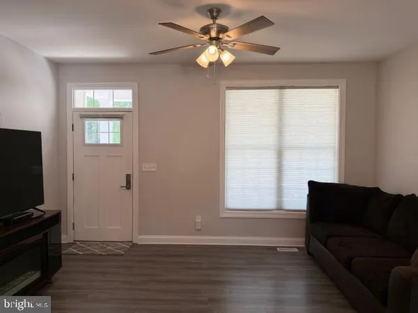 a living room with furniture wooden floor and a dining table