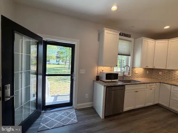 a kitchen with granite countertop cabinets stainless steel appliances and a window