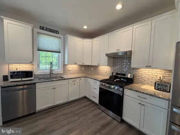 a kitchen with granite countertop stainless steel appliances and wooden cabinets