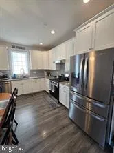 a kitchen with granite countertop white cabinets and stainless steel appliances