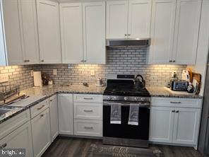 209 3rd Street Crumpton, MD 21628 - Photo 35 of 108 a kitchen with granite countertop white cabinets and stainless steel appliances