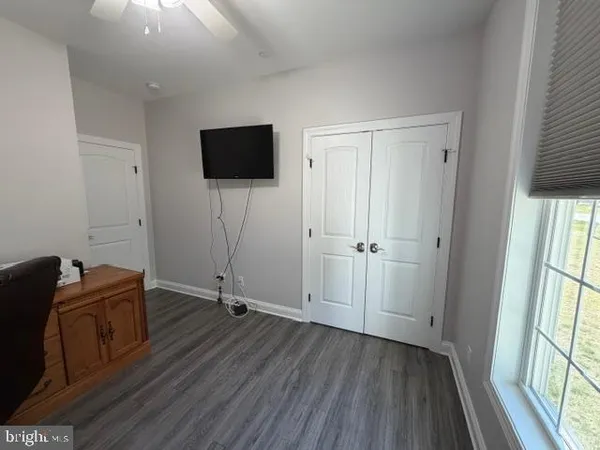 a bedroom with a bed and a flat tv screen on dresser
