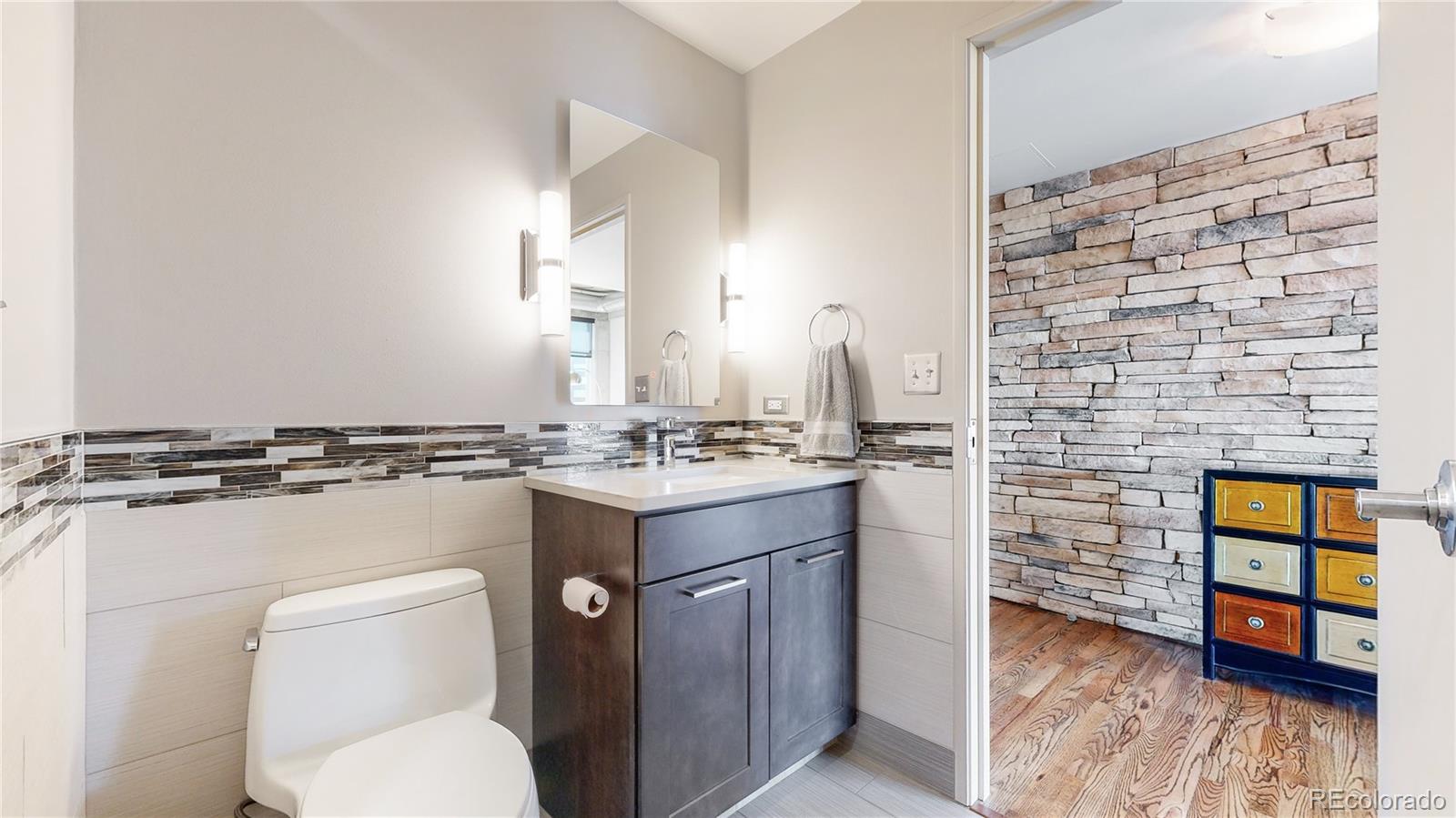 2000 Little Raven Street, Unit 702 Denver, CO 80202 - Photo 24 of 48 a bathroom with a toilet sink and mirror