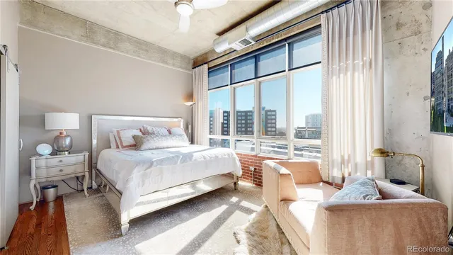 a bedroom with a bed and large window