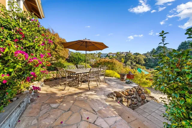 a view of a patio with a table and chairs under an umbrella