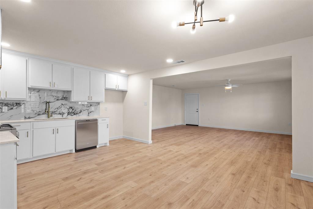 4325 Highland Street Lancaster, TX 75134 - Photo 13 of 35 a view of a kitchen with a sink and dishwasher a refrigerator with wooden floor