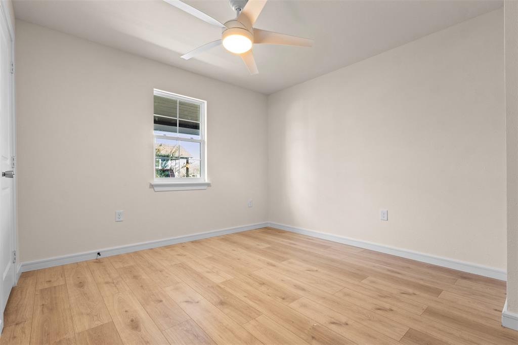4325 Highland Street Lancaster, TX 75134 - Photo 19 of 35 an empty room with wooden floor fan and windows