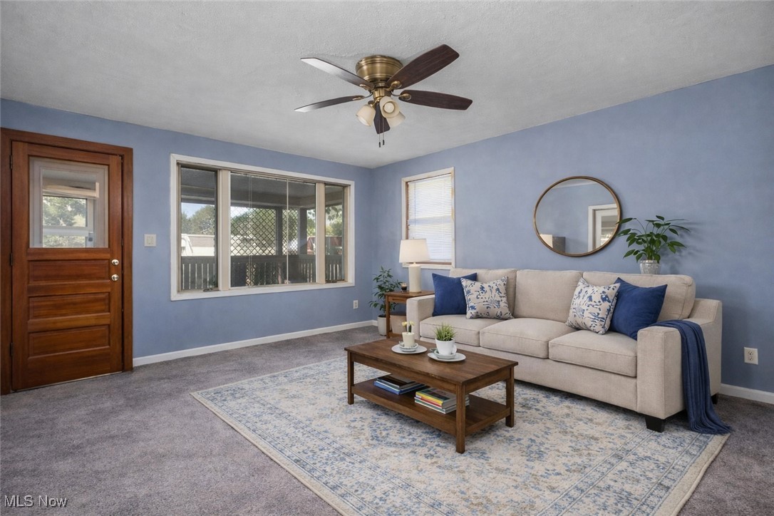 6927 North Wildacre Road Curtice, OH 43412 - Photo 4 of 44 Carpeted living room featuring ceiling fan and a textured ceiling