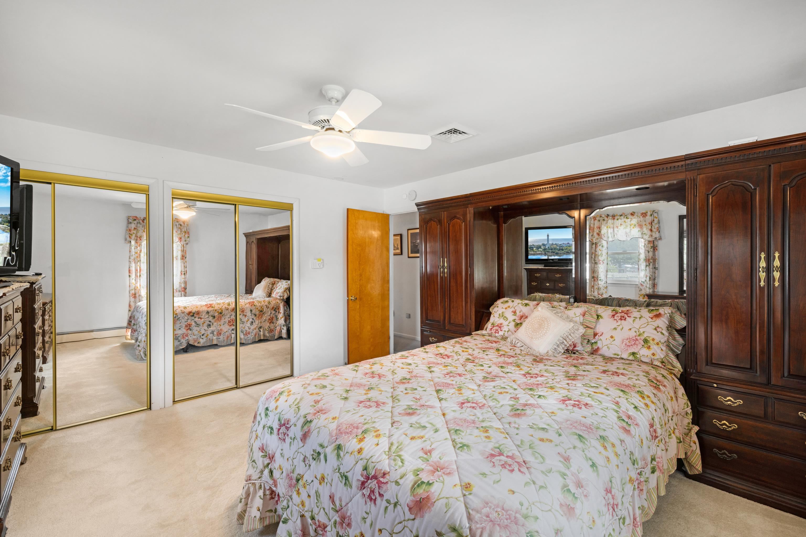 102 Teal Road Rio Grande, NJ 08242 - Photo 30 of 49 a bedroom with a large bed and a chandelier