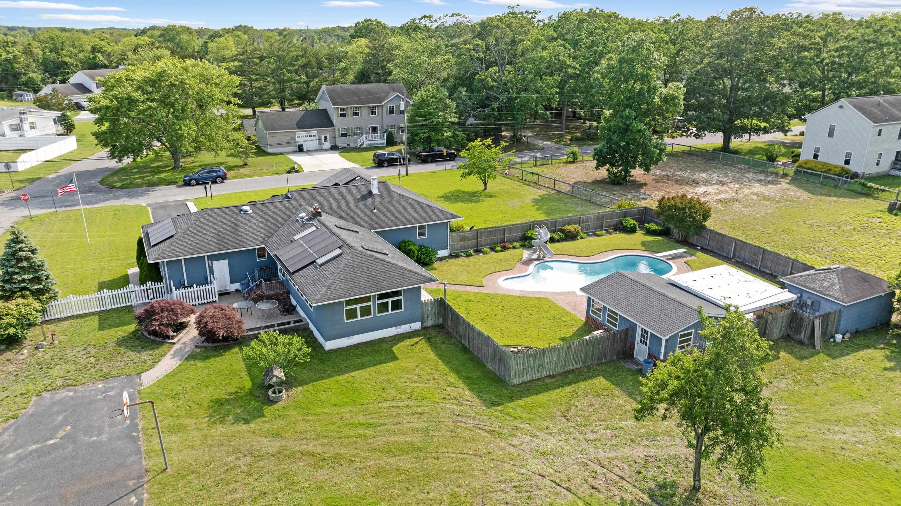 102 Teal Road Rio Grande, NJ 08242 - Photo 5 of 49 an aerial view of a swimming pool with lawn chairs and large trees